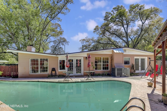 rear view of property featuring french doors, central air condition unit, fence, and a patio area