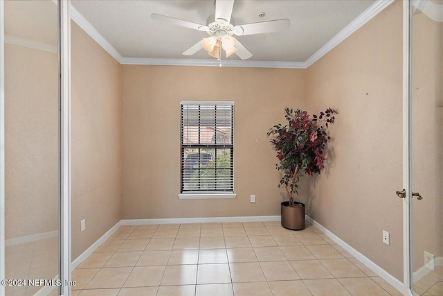 tiled empty room with ceiling fan and ornamental molding