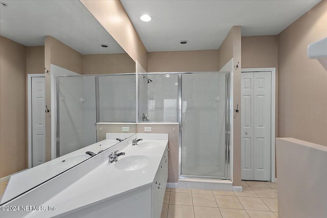 bathroom with tile patterned flooring, vanity, and walk in shower