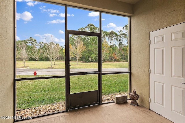 doorway to outside featuring carpet floors and a healthy amount of sunlight