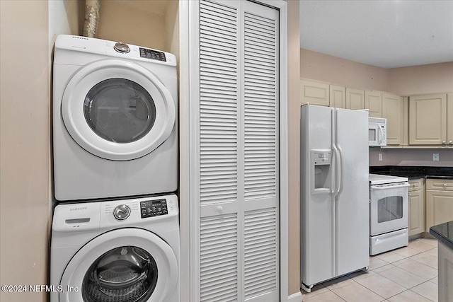 clothes washing area featuring stacked washing maching and dryer and light tile patterned flooring