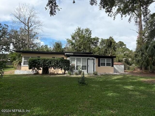 back of property featuring a lawn