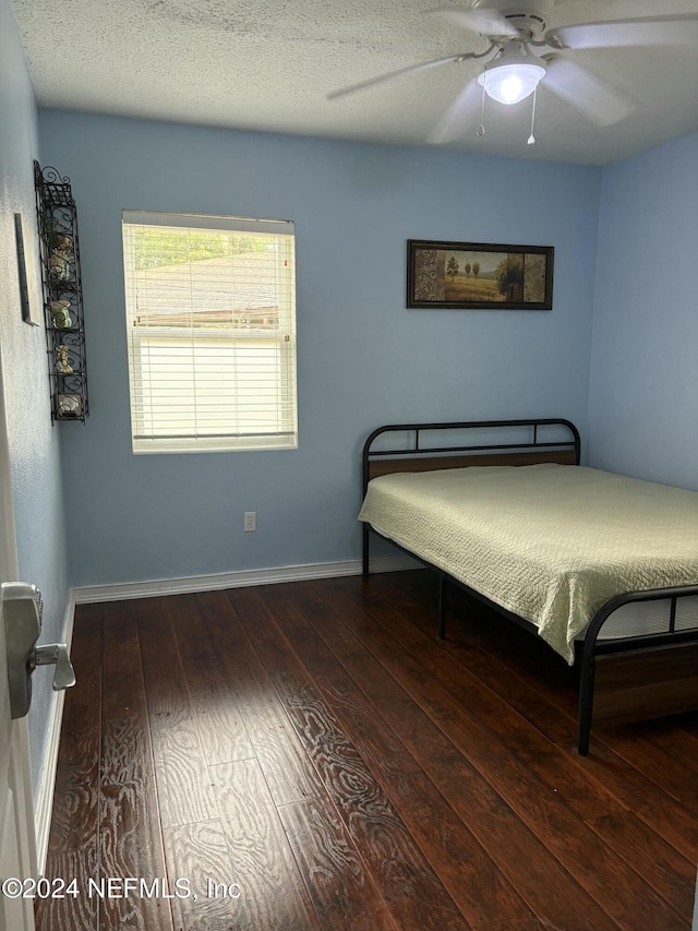 bedroom with hardwood / wood-style floors, a textured ceiling, and ceiling fan