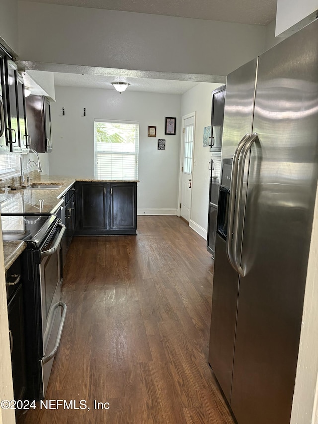 kitchen with stainless steel fridge, range with electric cooktop, dark hardwood / wood-style floors, and sink