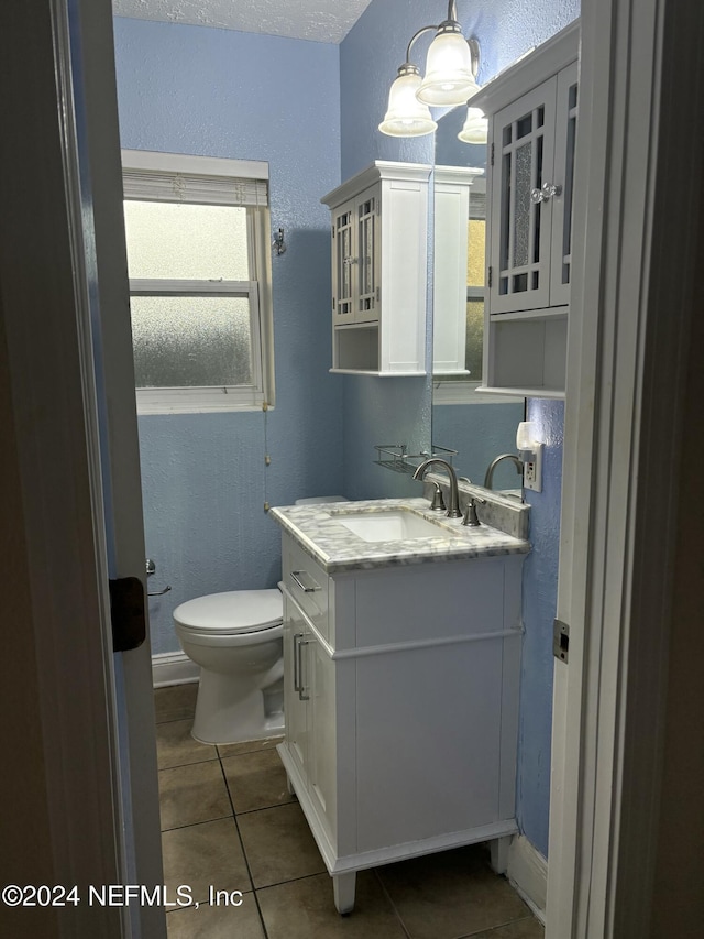 bathroom with tile patterned flooring, vanity, and toilet