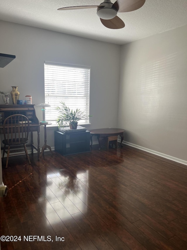 office area with ceiling fan, dark hardwood / wood-style flooring, and a textured ceiling