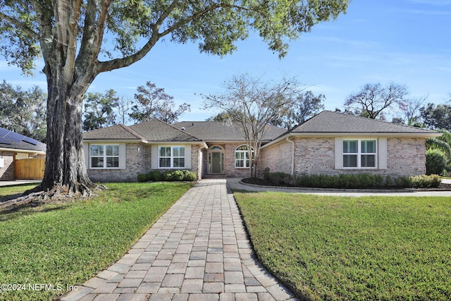 single story home featuring a front lawn