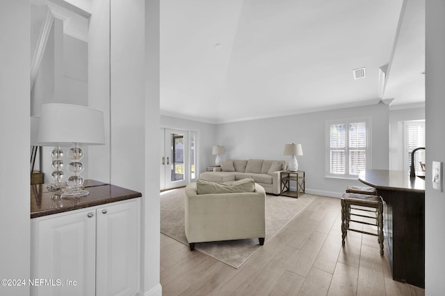 living room with light wood-type flooring and ornamental molding