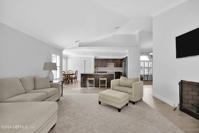 living room with crown molding, a healthy amount of sunlight, lofted ceiling, and light wood-type flooring