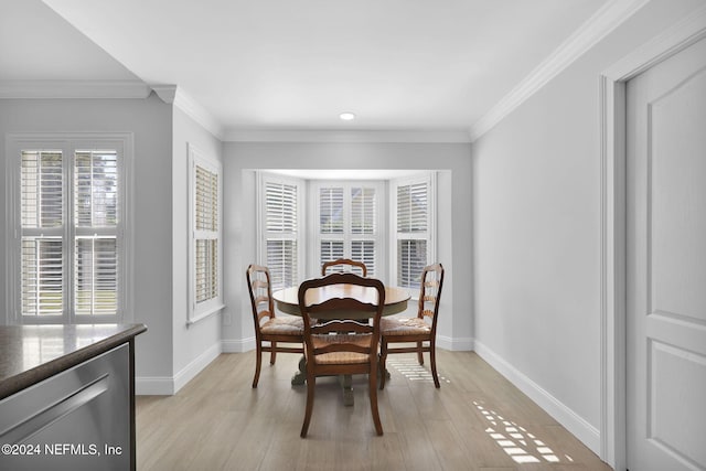 dining area featuring light wood-type flooring and crown molding