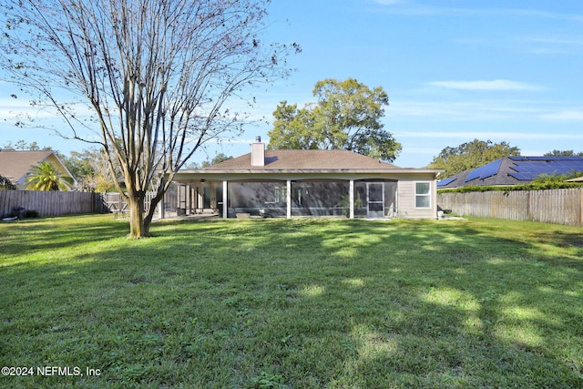 back of property with a sunroom and a yard