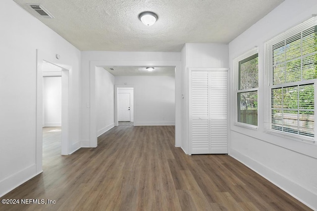 hall featuring dark hardwood / wood-style flooring and a textured ceiling