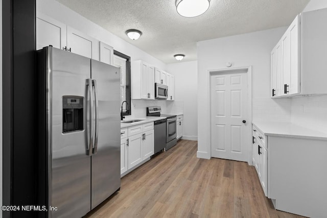 kitchen with white cabinets, decorative backsplash, sink, and appliances with stainless steel finishes