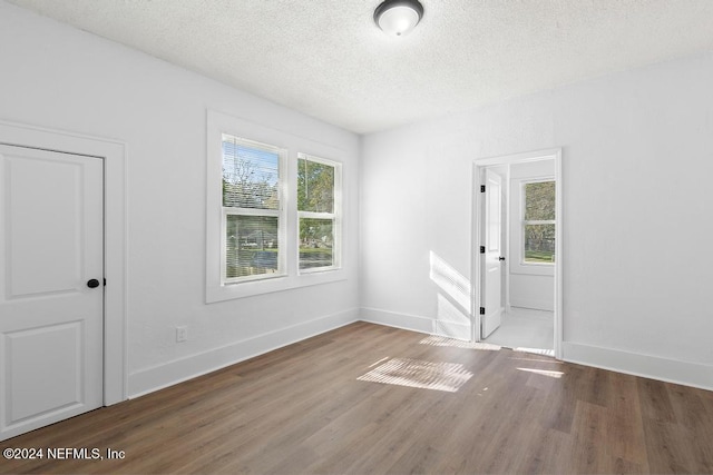 spare room with wood-type flooring and a textured ceiling