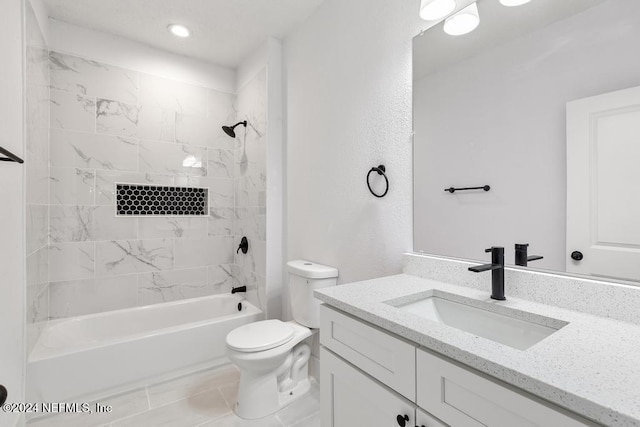 full bathroom featuring tile patterned flooring, vanity, toilet, and tiled shower / bath