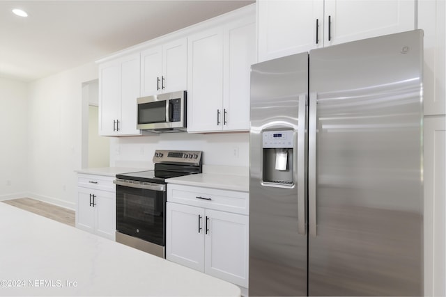 kitchen featuring white cabinets, stainless steel appliances, and light hardwood / wood-style floors