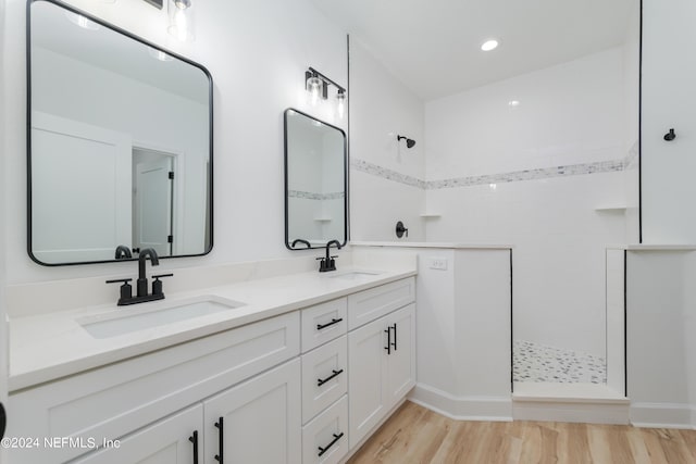 bathroom with vanity, wood-type flooring, and tiled shower