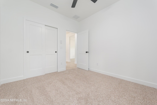 unfurnished bedroom with carpet floors, a closet, and ceiling fan