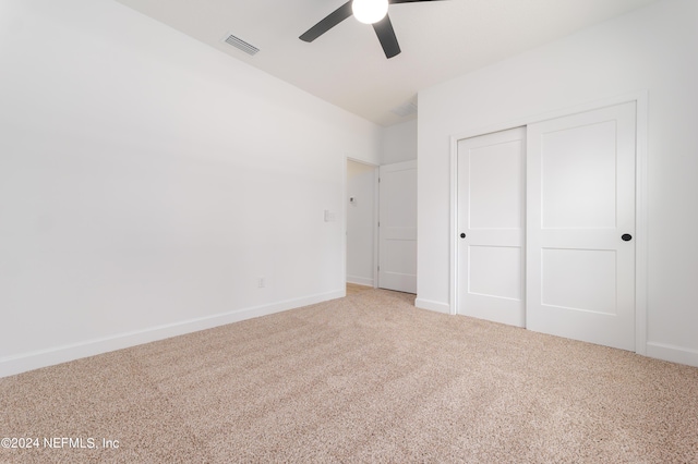 unfurnished bedroom with ceiling fan, a closet, and carpet floors