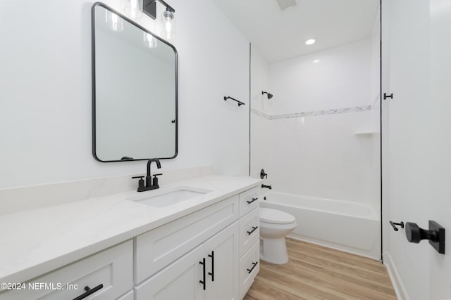 full bathroom featuring vanity, hardwood / wood-style flooring, toilet, and tiled shower / bath combo