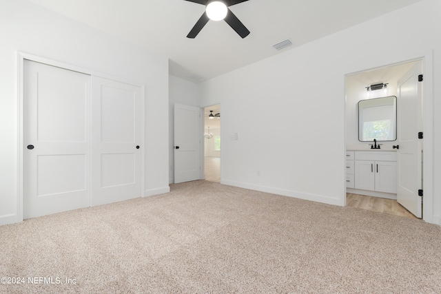 unfurnished bedroom with connected bathroom, a closet, ceiling fan, and light colored carpet