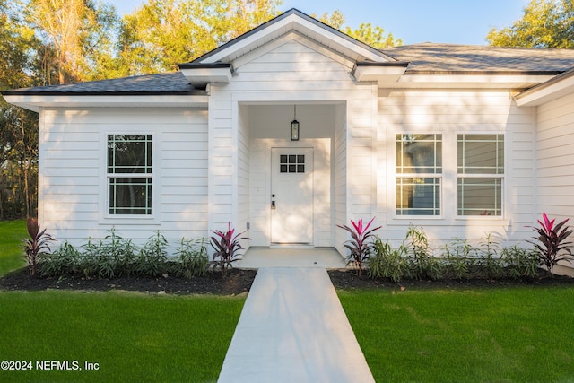 property entrance with a lawn