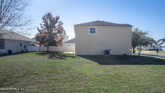 view of home's exterior with cooling unit and a yard