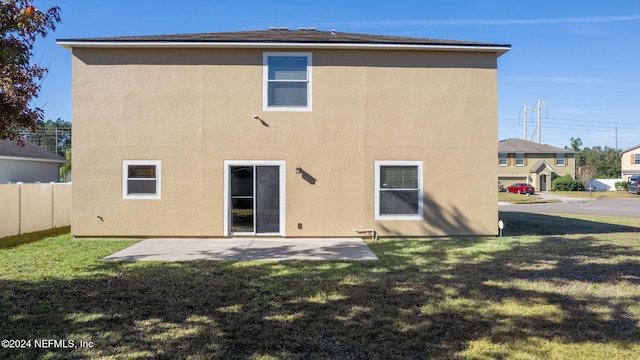 rear view of house featuring a yard and a patio