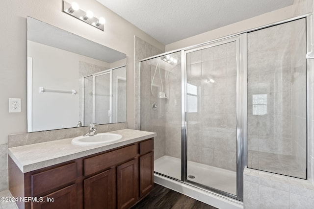 bathroom with vanity, hardwood / wood-style floors, a textured ceiling, and an enclosed shower