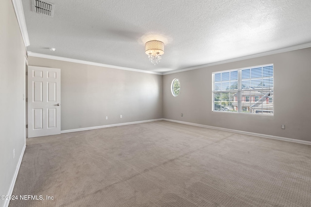 empty room with a chandelier, light colored carpet, a textured ceiling, and ornamental molding