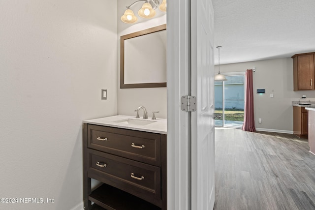 bathroom featuring vanity, wood-type flooring, and a textured ceiling