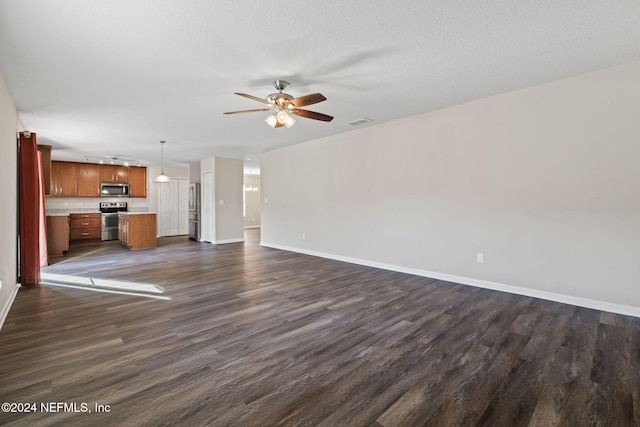 unfurnished living room featuring dark hardwood / wood-style floors, ceiling fan, and a textured ceiling