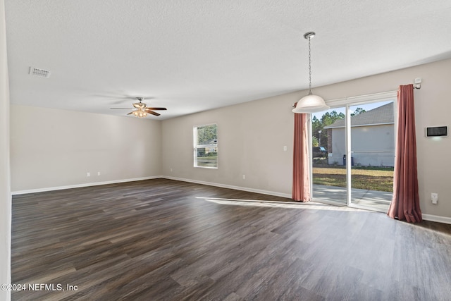 unfurnished room with a textured ceiling, ceiling fan, and dark hardwood / wood-style floors