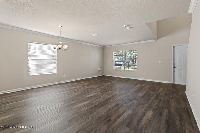 unfurnished room featuring a textured ceiling, dark hardwood / wood-style flooring, an inviting chandelier, and ornamental molding