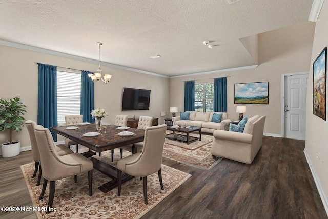 dining area with dark hardwood / wood-style flooring, ornamental molding, a textured ceiling, and a chandelier