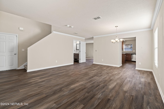 unfurnished living room with dark hardwood / wood-style flooring, ornamental molding, a textured ceiling, and a chandelier