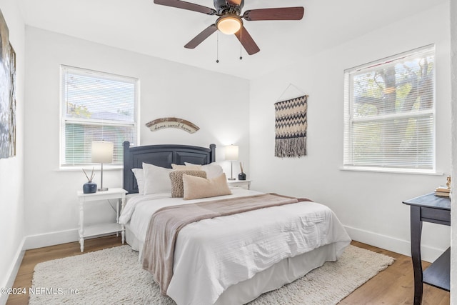 bedroom featuring multiple windows, ceiling fan, and light hardwood / wood-style floors