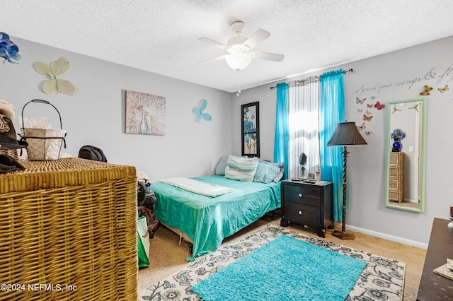 bedroom featuring carpet flooring, a textured ceiling, and ceiling fan