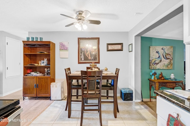 tiled dining area with ceiling fan and a textured ceiling