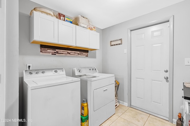 laundry area featuring cabinets, light tile patterned floors, and washing machine and dryer