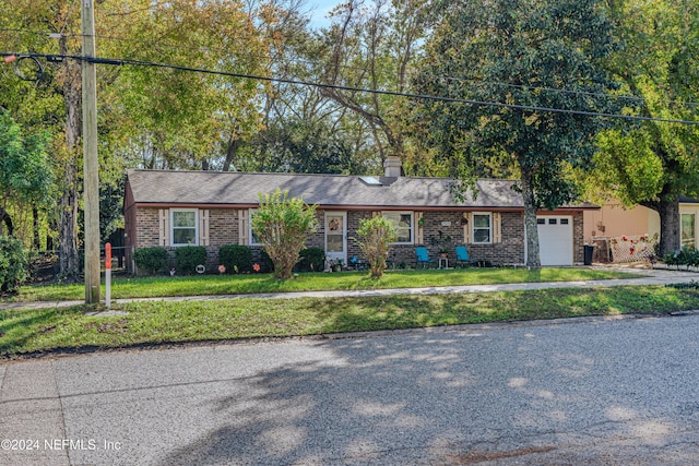 ranch-style house featuring a garage and a front lawn