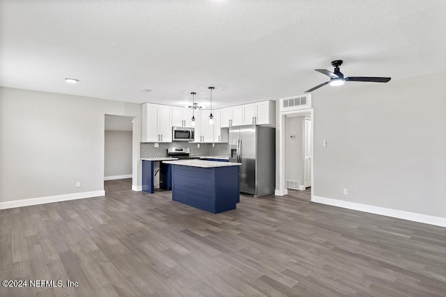 kitchen with stainless steel appliances, pendant lighting, wood-type flooring, white cabinetry, and a kitchen island