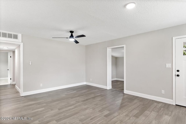 unfurnished room featuring wood-type flooring, a textured ceiling, and ceiling fan