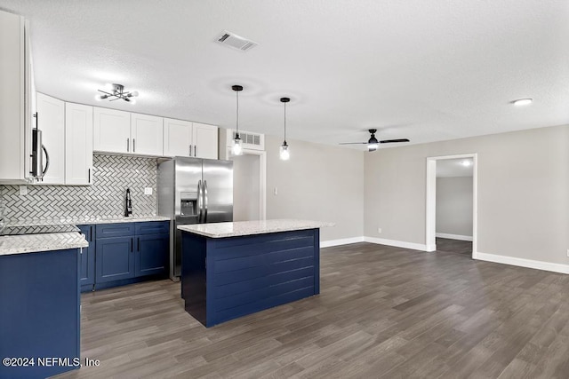 kitchen featuring dark hardwood / wood-style flooring, ceiling fan, pendant lighting, white cabinets, and a kitchen island