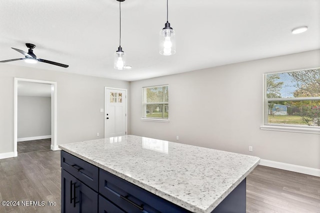 kitchen with ceiling fan, a center island, decorative light fixtures, and dark hardwood / wood-style floors