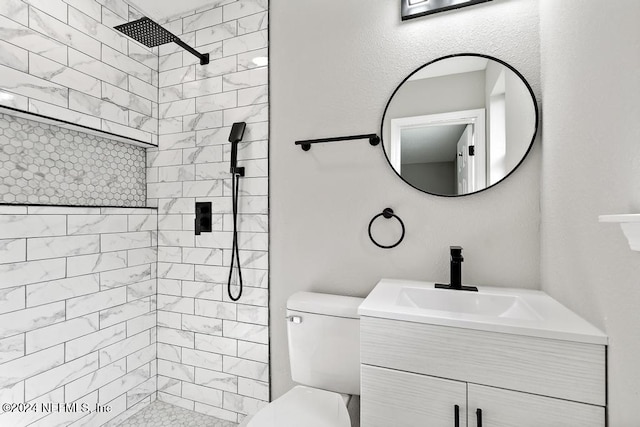 bathroom featuring tiled shower, vanity, and toilet