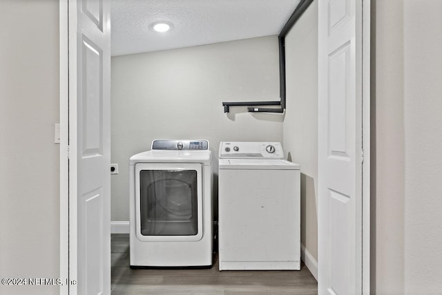 laundry room with hardwood / wood-style floors, washer and dryer, and a textured ceiling