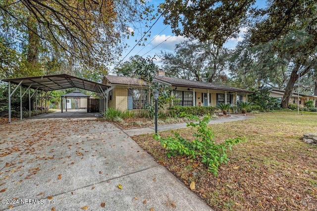 ranch-style house featuring a carport and a front lawn