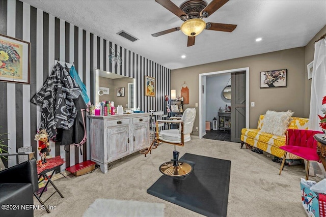 carpeted living room featuring a textured ceiling and ceiling fan