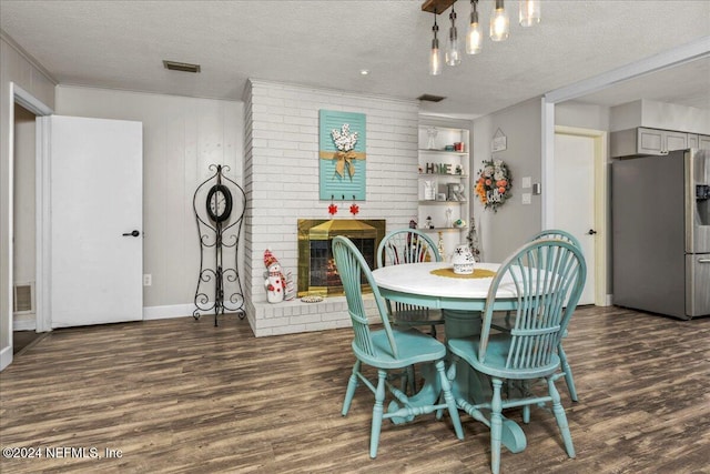 dining area featuring dark hardwood / wood-style floors, a fireplace, and a textured ceiling